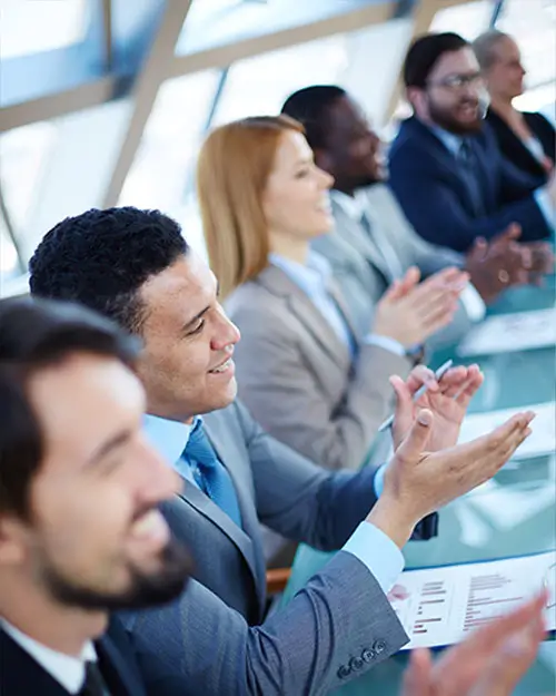 A diverse corporate meeting. Everyone is clapping.