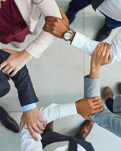 Five diverse corporate individuals linking arms.